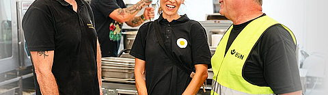 Paul Cusack und Clara Seipp von Sunny Side Catering im Austausch mit BGN-Arbeitsschutzexperte Stephan Thomassohn. | © Tony Matysik - CuatroCeroDesign (CCD) Paul Cusack und Clara Seipp von Sunny Side Catering im Austausch mit BGN-Arbeitsschutzexperte Stephan Thomassohn.