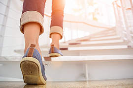 Frau geht die Treppe hinauf