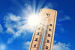 Ein Thermometer vor einem blauen Himmel mit Sonne zeigt über 30 Grad Celsius an.