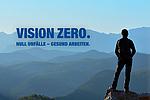 Eine Person steht auf einem Berg und schaut in die Weite. Im Berg ist das Logo für "VISION ZERO".
