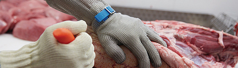 Ausbeinarbeit mit Schnittschutzhandschuh an Messer führender Hand und Stechschutzhandschuh an der anderen Hand | © Oliver Rüther / BGN Ausbeinarbeit mit Schnittschutzhandschuh an Messer führender Hand und Stechschutzhandschuh an der anderen Hand